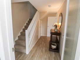 A hallway with a staircase and console table at 1 Island View in Thurlestone