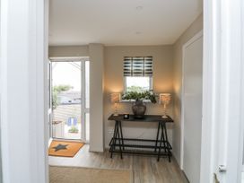 A hallway with a table, lamps, and a window at 1 Island View in Thurlestone