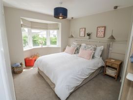 A bedroom with a bed and decorative items at 1 Island View in Thurlestone