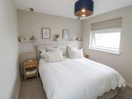 A bedroom with a bed and nightstand at 1 Island View Thurlestone