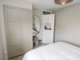 A bedroom with wardrobe and mirror at 1 Island View Thurlestone
