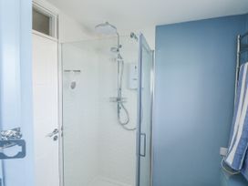 A shower with glass enclosure and towel rack at 1 Island View in Thurlestone