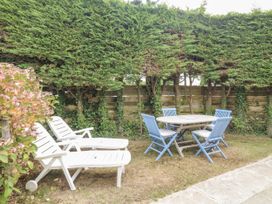 A garden with lounge chairs and a dining table at 1 Island View Thurlestone