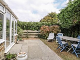 A garden with a table and chairs at 1 Island View Thurlestone
