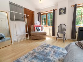 A bedroom with a mirror and a chair at The Cow Shed in 