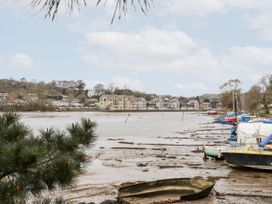 A view of boats by a riverbank and buildings in the background at The Cow Shed in 