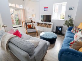 A living room with a sofa, armchair, TV and coffee table at Old Felixstowe, Bath Road in Felixstowe, Suffolk