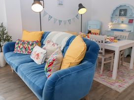A living room with a blue sofa and dining area at Old Felixstowe, Bath Road, Felixstowe, Suffolk