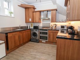 A kitchen with wooden cabinets and appliances at Old Felixstowe, Bath Road in Felixstowe, Suffolk