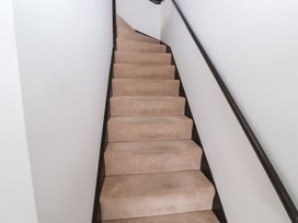 A staircase with carpeted steps and a handrail at Old Felixstowe, Bath Road