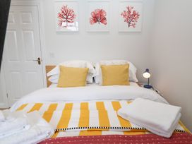 A bedroom with a bed and wall art at Old Felixstowe, Bath Road, Felixstowe, Suffolk