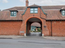 An archway entrance with brick walls and a sign at The Mews in Felixstowe, Suffolk