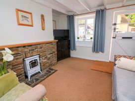 A living room with a television and fireplace at 2 The Square Hope Cove
