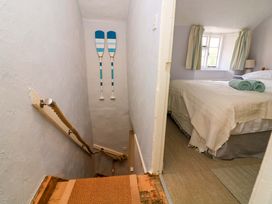 A staircase leading to a bedroom with towels and a lamp at 2 The Square Hope Cove