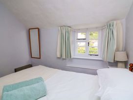 A bedroom with a bed and window at 2 The Square Hope Cove
