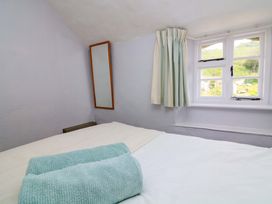 A bedroom with towels on a bed at 2 The Square in Hope Cove