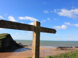 A signpost indicating coast paths to Salcombe and Bantam near the beach