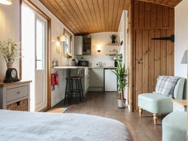 A small kitchen and seating area with wooden ceiling and floor at The Heron in Lode near Bottisham