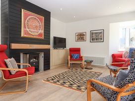 A living room with a fireplace and chairs at Clova in Brixham