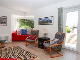 A living room with a red sofa and armchairs at Clova in Brixham
