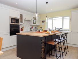 A kitchen with an island and stools at Clova in Brixham