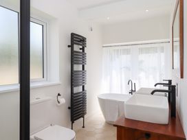 A bathroom with a bathtub and sinks at Clova in Brixham