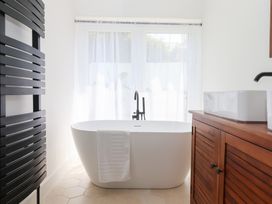 A bathroom with a bathtub and a cabinet at Clova in Brixham