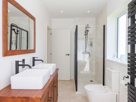 A bathroom with a shower and double wash basins at Clova in Brixham