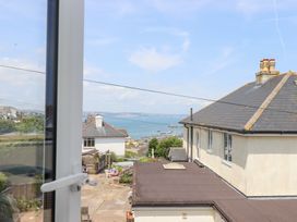 A view from a window showing water, boats, and buildings at Clova Brixham