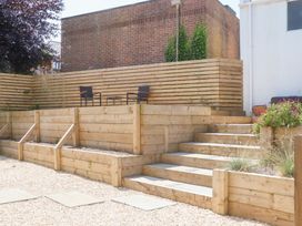 A garden with wooden decking and steps at Clova in Brixham