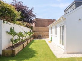 A garden with plants and seating area at Clova in Brixham