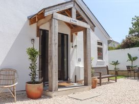 An outdoor entrance area with a bench and plants at Clova in Brixham