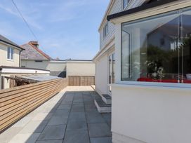 A paved outdoor area with fence and house at Clova Brixham