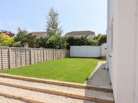 A garden with grass and a wooden pathway at Clova in Brixham