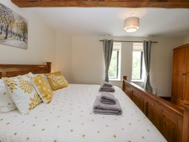 A bedroom with a bed and wardrobe at Lakeside Barn in Aylsham