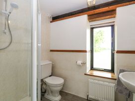 A bathroom with a shower, toilet, and sink at Lakeside Barn Aylsham