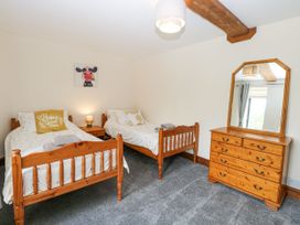 A bedroom with twin beds and a chest of drawers at Lakeside Barn in Aylsham