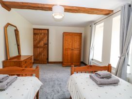 A bedroom with twin beds and wooden furniture at Lakeside Barn Aylsham
