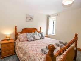 A bedroom with a bed and bedside table at Lakeside Barn Aylsham
