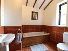 A bathroom with bathtub, sink, and toilet at Lakeside Barn Aylsham