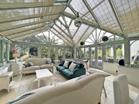 A conservatory with sofas and a coffee table at Trenare in Truro