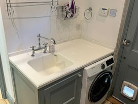 A laundry room with a sink and washing machine at Trenare in Truro