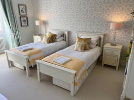 A bedroom with twin beds and lamps at Trenare in Truro