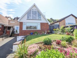 A house with a sloped roof flower beds and a lawn at 67 Pendre Avenue Prestatyn