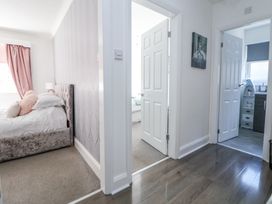 A hallway with open white doors leading to bedrooms and a bathroom at 67 Pendre Avenue Prestatyn