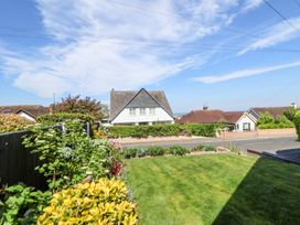 A front yard with grass and shrubs facing a street with houses at 67 Pendre Avenue in Prestatyn