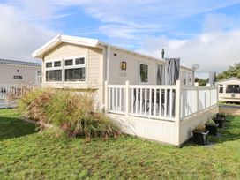 A mobile home with a deck and plants outside Number 34 Foxburrow Hang in Great Yarmouth