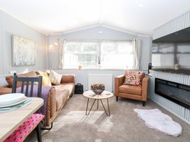 A living room with a sofa and armchair at Number 34 Foxburrow Hang in Great Yarmouth