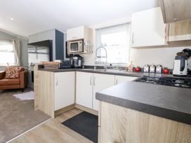 A kitchen with appliances and cabinets at Number 34 Foxburrow Hang in Great Yarmouth