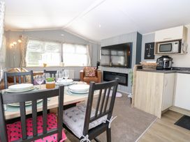 A living room with a dining area and kitchen appliances at Number 34 Foxburrow Hang in Great Yarmouth